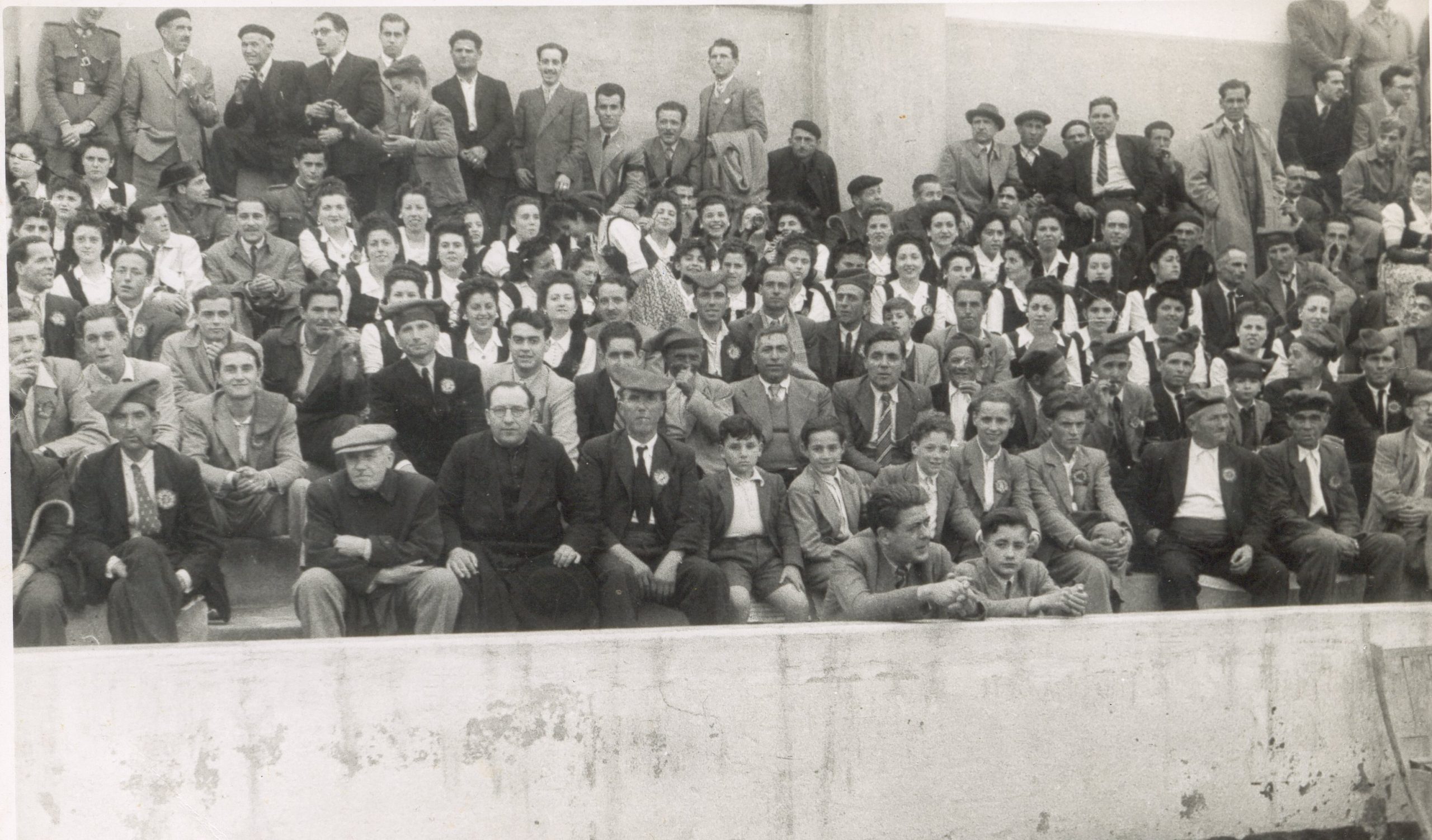 L'Orfeó El Rossinyol de les Garrigues a les graderies dl camp del Nàstic de Tarragona, l'11 de maig de 1947. Mossèn Vila a primera fila. Font: Arxiu fotogràfic de l'Associació Cultural El Cérvol.